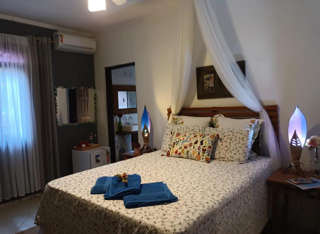 um quarto com uma cama com duas toalhas azuis em LE BOUTIQUE SUÍTES - PRAIA de MARESIAS em Maresias