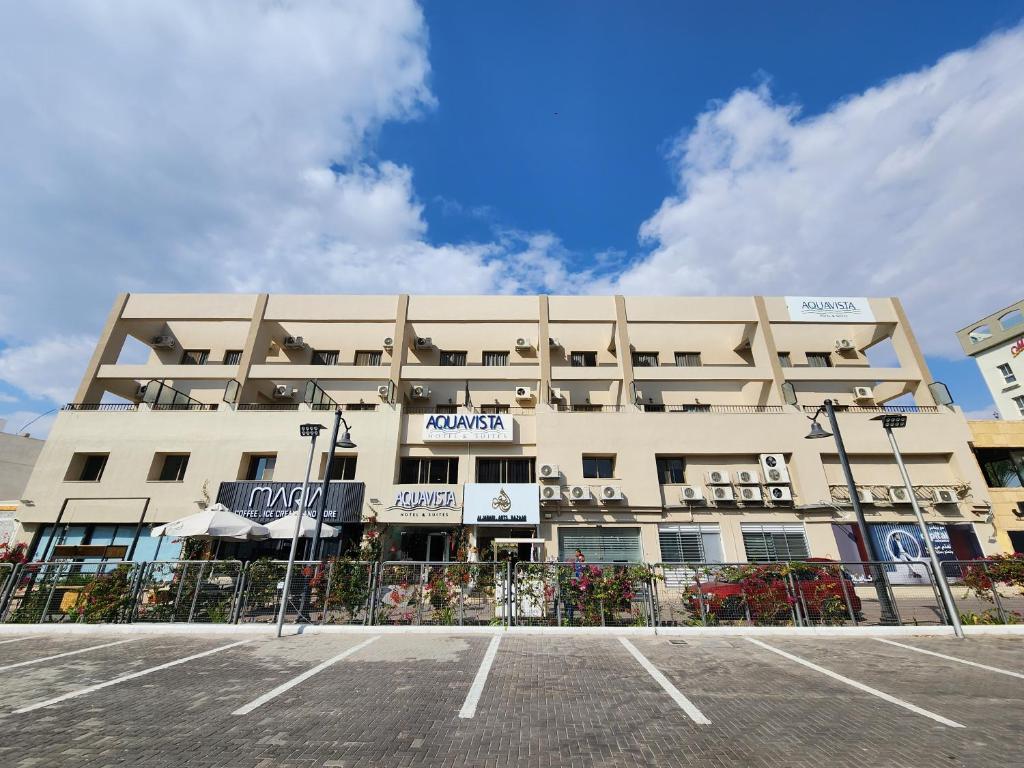 アカバにあるAquavista Hotel & Suitesの正面に駐車場がある建物