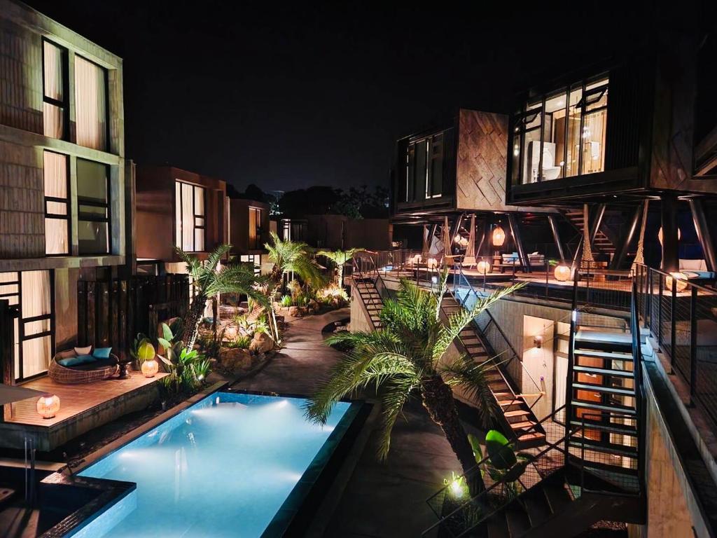 an outdoor swimming pool with palm trees next to a building at Deer Chaser Hotel in Yuchi