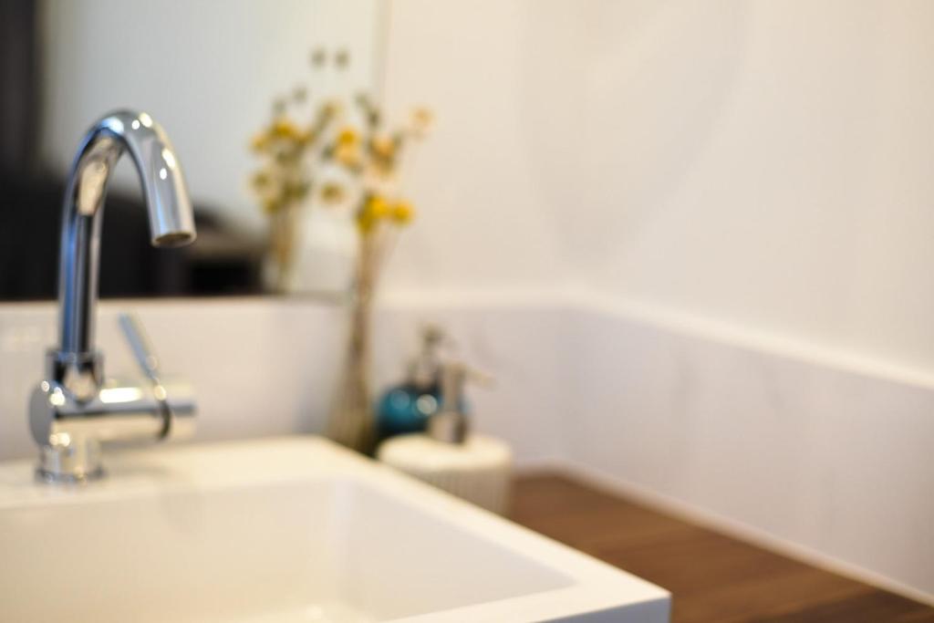 a white sink in a kitchen with a vase of flowers at Bremer Bay B&B in Bremer Bay