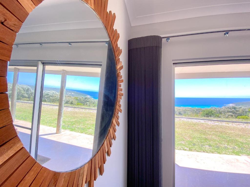 a mirror in a room with a view of the ocean at Bremer Bay B&B in Bremer Bay