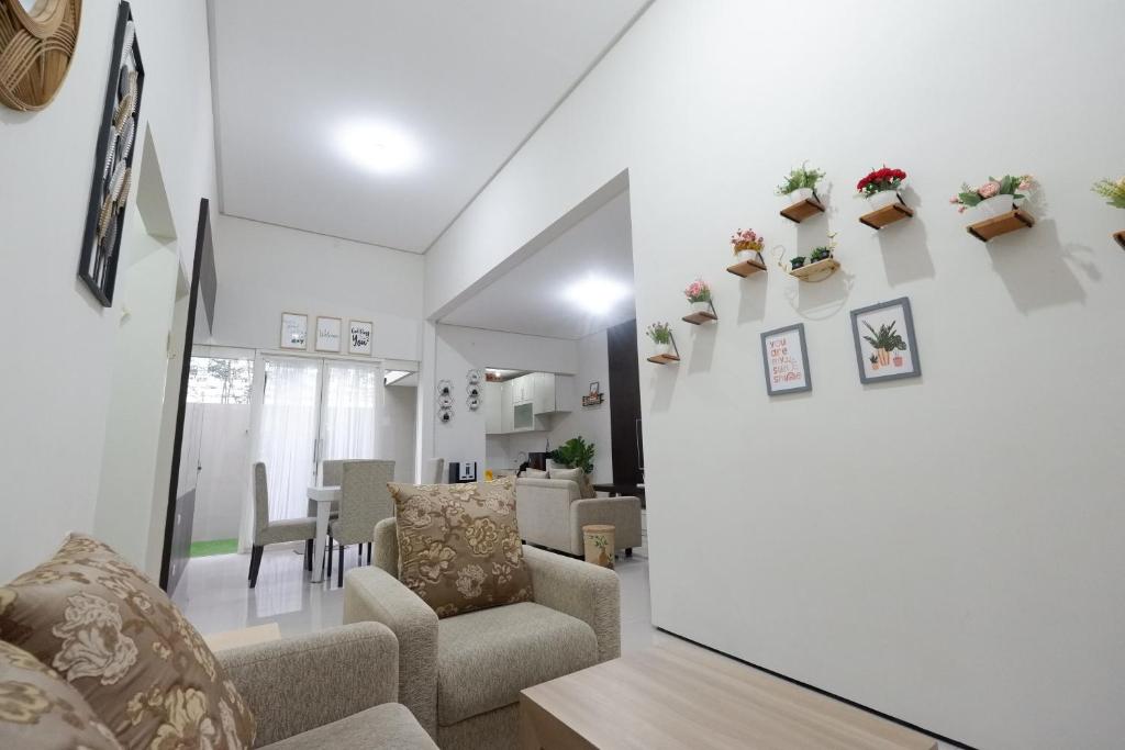 uma sala de estar com cadeiras e plantas na parede em Villa Brassia - 3 Bedrooms 