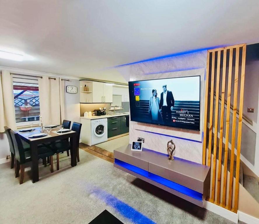 sala de estar con mesa de comedor y TV en Skye View Cottage, en Portree