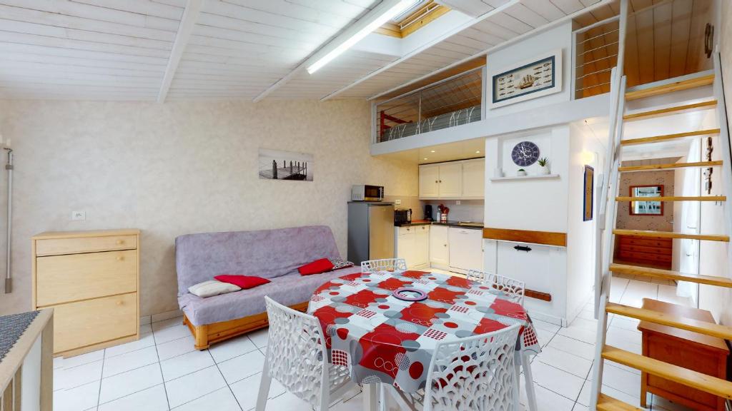 cocina y sala de estar con mesa y sofá en Charmante Ferme Marine avec piscine commune en Brétignolles-sur-Mer