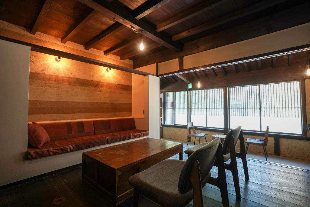 a living room with a couch and a table and chairs at 赭Soho Yunotsu Old Village Inn & Bar in Ōmorichō