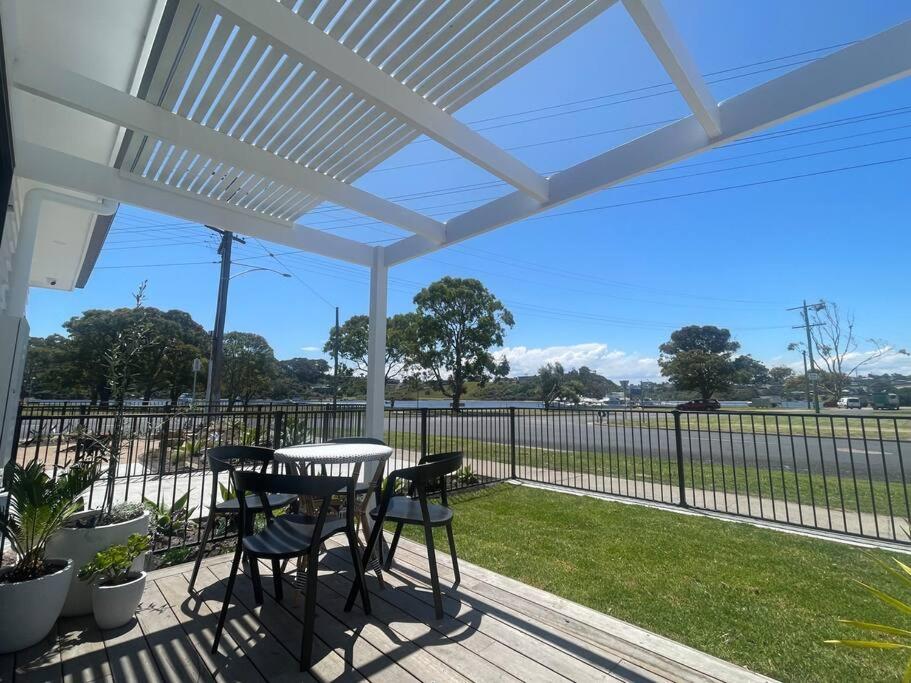 a white pergola on a deck with a table and chairs at Quarterdeck Lakes Entrance 2br *Waterfront* Apartment in Lakes Entrance