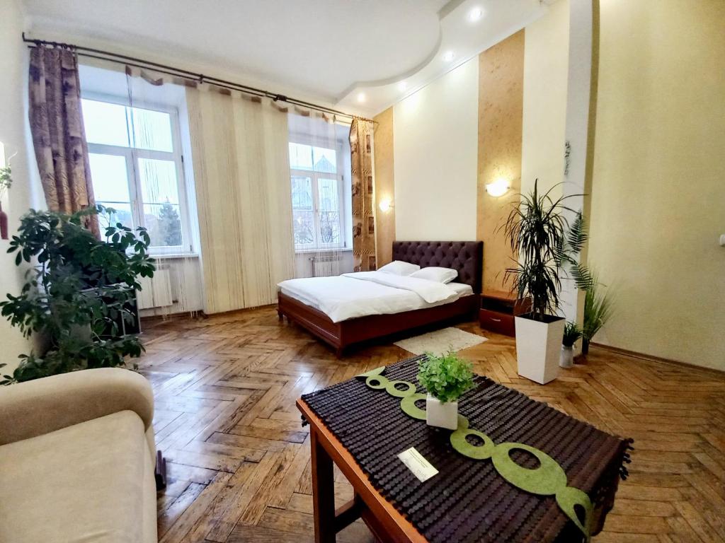 uma sala de estar com uma cama e uma mesa de centro em Ratusha Apartments em Lviv
