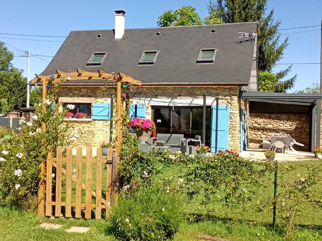 une maison avec une clôture en bois devant elle dans l'établissement GITE LA PEYRADE HAUTES PYRENEES, à Artiguemy