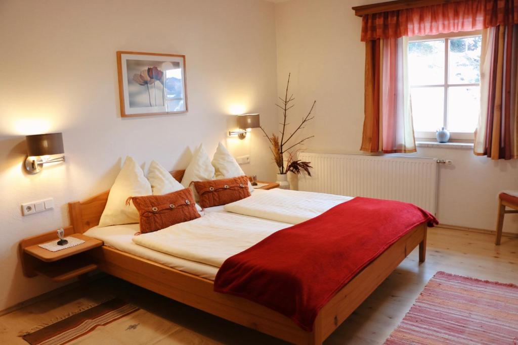 a bedroom with a large bed with a red blanket at Molteraugut in Mühlbach am Hochkönig