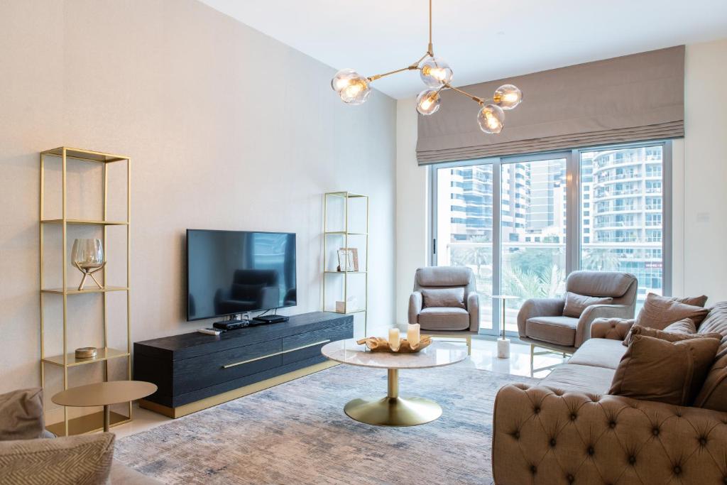 a living room with a couch and a tv at Boutique Living - Marina Wharf in Dubai