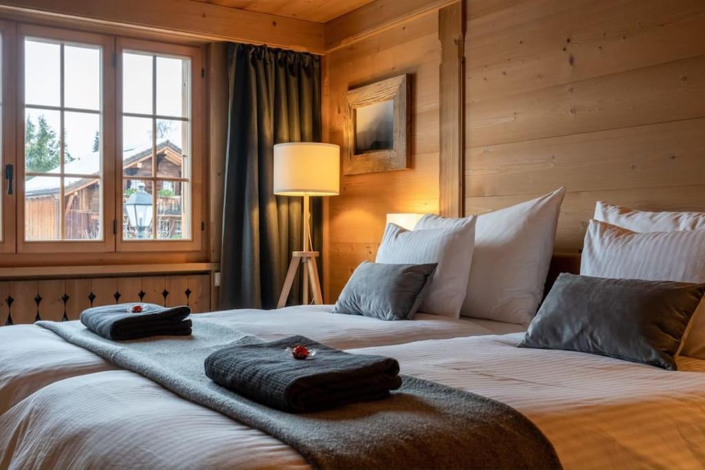 a bedroom with two beds with towels on them at Charming Alpine Apartment Gstaad in Gstaad