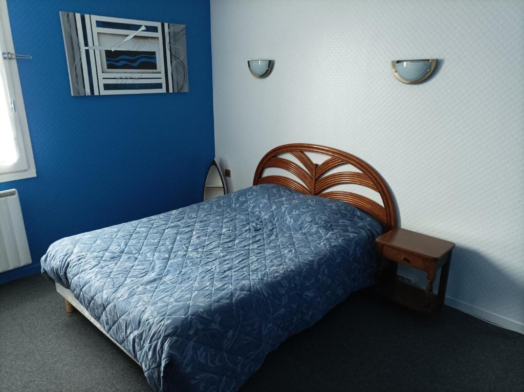 a bedroom with a bed in a blue room at La Croisière in Louvetot