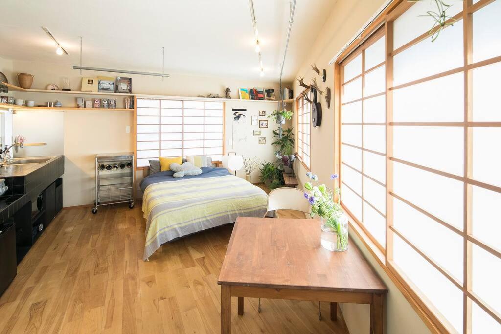 Un dormitorio con una cama y una mesa. en PDO INN Coffee & Open-air bath on the roof, en Tokio