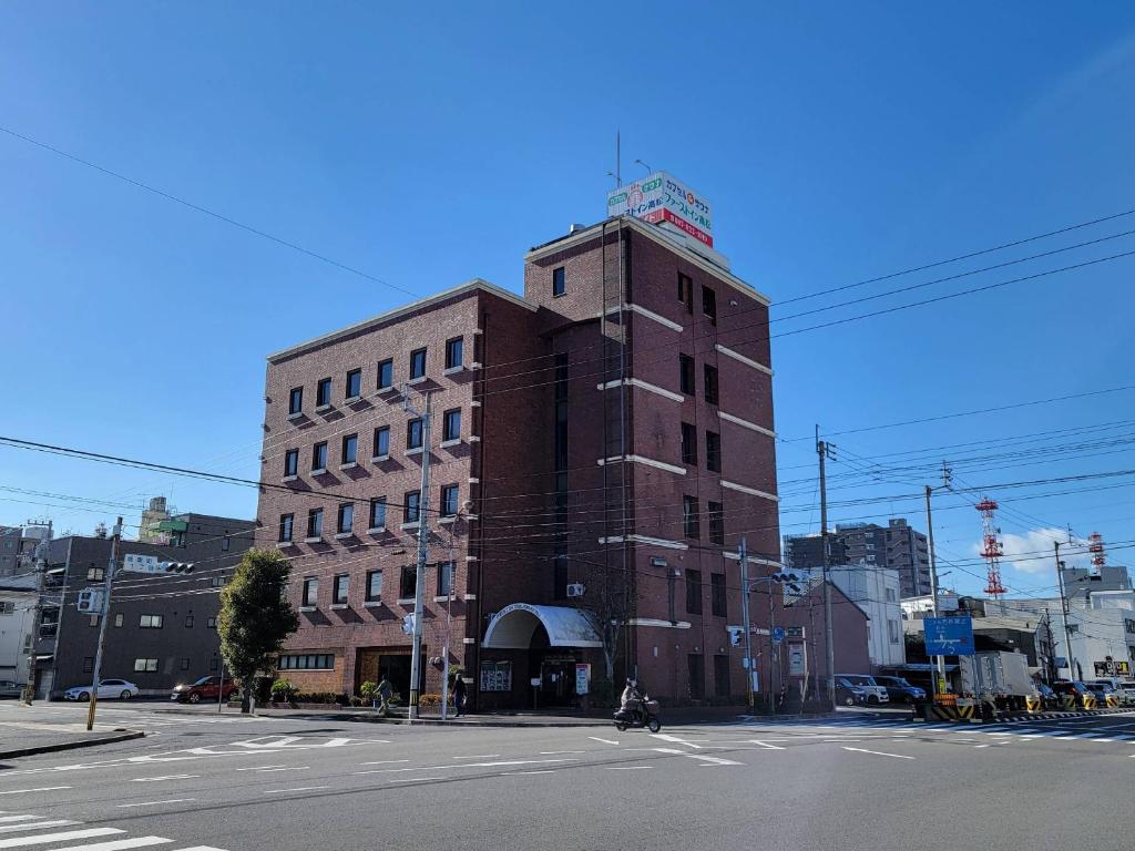 un grand bâtiment en briques au coin d'une rue dans l'établissement First Inn Takamatsu, à Takamatsu