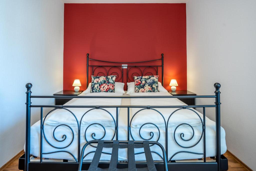 a bedroom with a bed with a red wall at T E M P F E R 2 Apartments & Rooms with new WELLNESS in Kranjska Gora