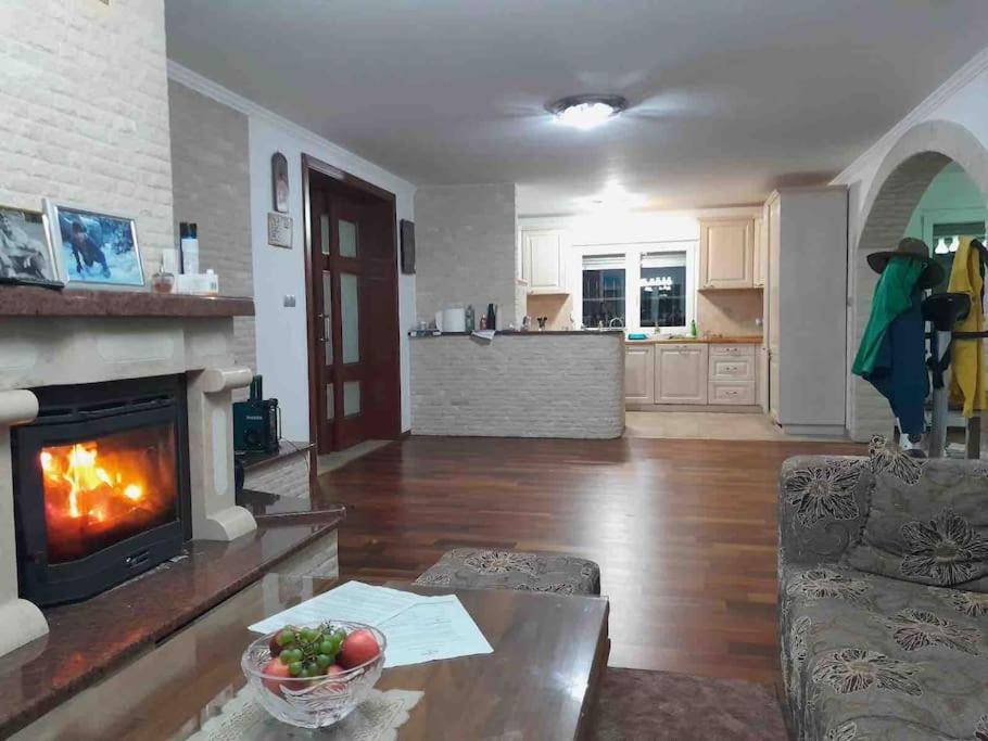 a living room with a fireplace and a table with a bowl of fruit at Peaceful house Velika Kladusa 1km from centre in Velika Kladuša