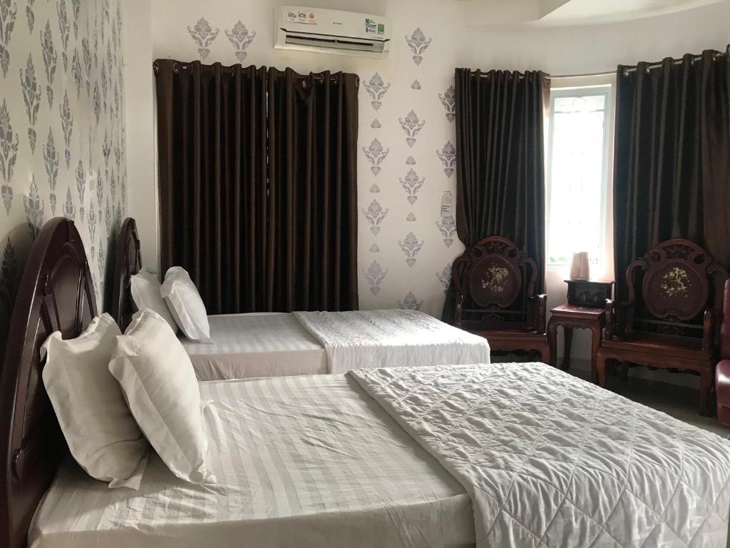 een slaapkamer met 2 bedden en een raam bij khách sạn Hồng Tâm in Ho Chi Minh-stad