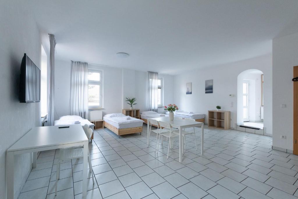 a white living room with a couch and a table at T&K Apartments - 1-3 Zimmer Apartments - Essen in Essen