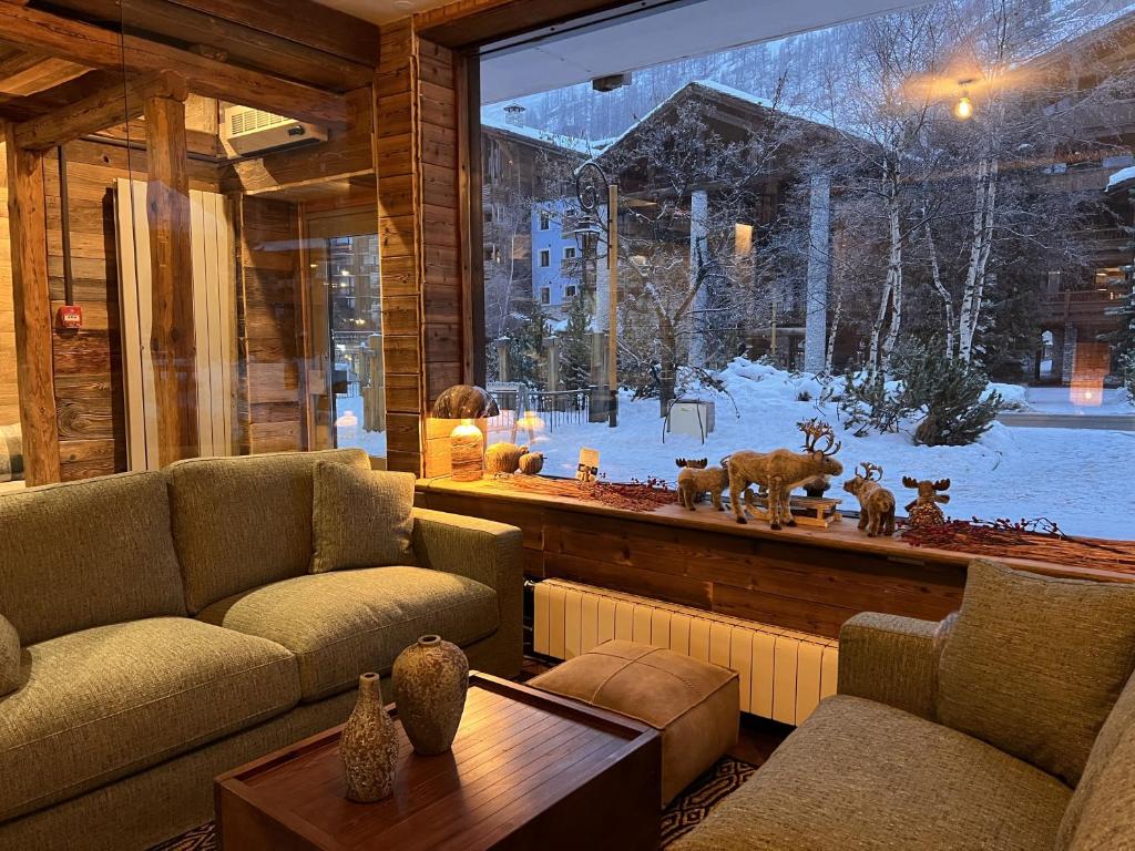 a living room with couches and a large window at Everest Hotel in Val-d'Isère