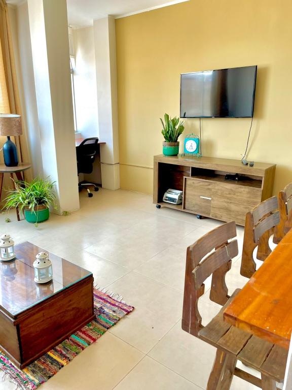 a living room with a table and a tv at Cálido Departamento en Chincha Alta in Chincha Alta