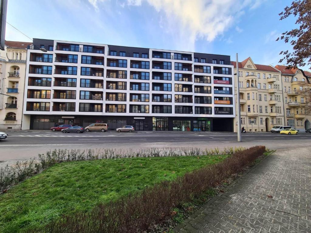 un gran edificio con coches estacionados en un estacionamiento en Copper Apartment Free Parking, en Wroclaw