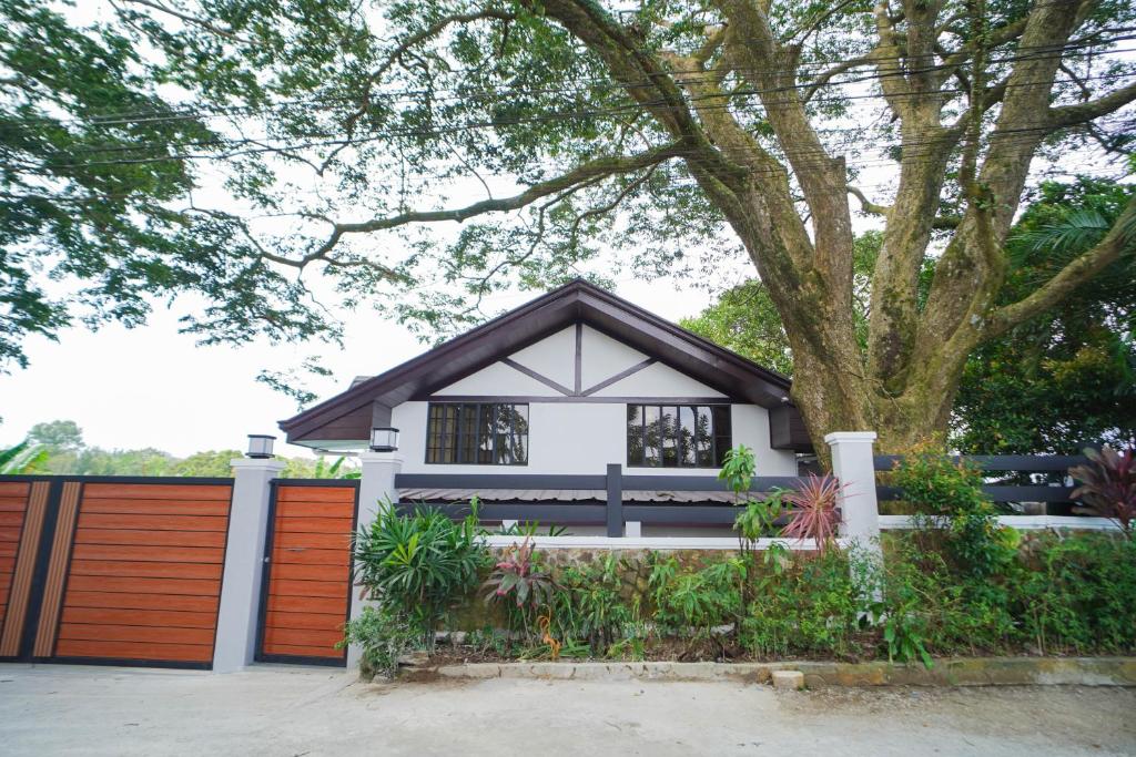 a small house with a fence and a tree at Balay Greenika Tagyatay Private Pool in Tagaytay