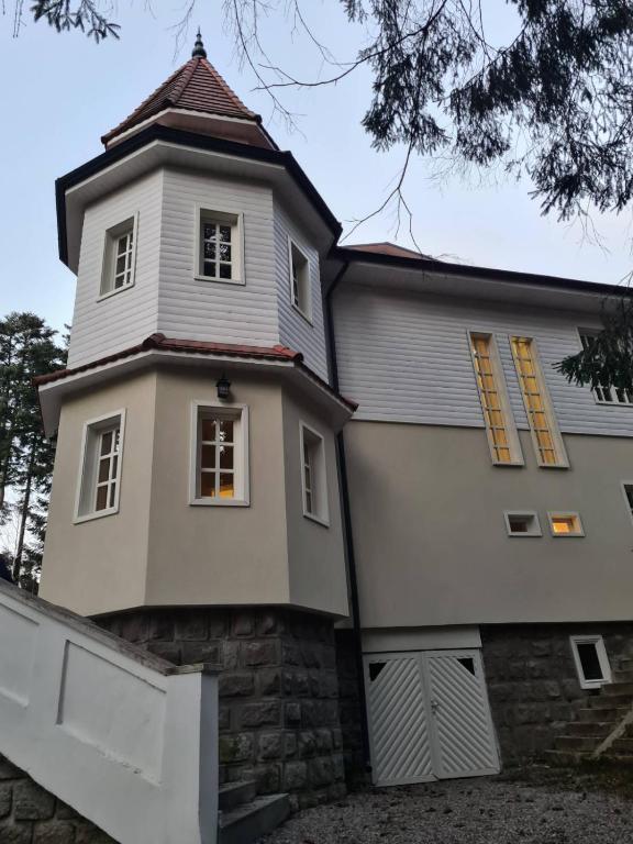 a large white building with a tower on top at Miniszteri House in Băile Tuşnad