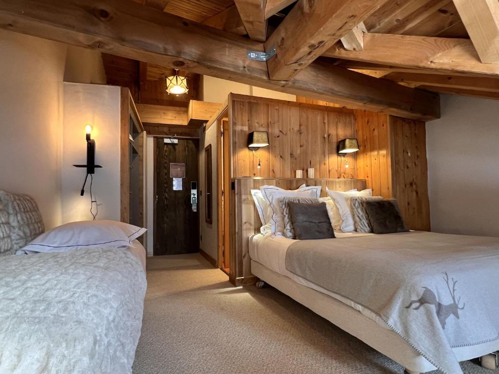 a bedroom with two beds and wooden walls at Everest Hotel in Val-d'Isère
