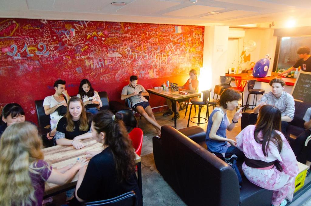 a group of people sitting in a room at Kimchee Busan Downtown Guesthouse in Busan