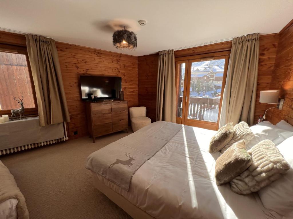 a bedroom with a large bed and a television at Everest Hotel in Val-d'Isère