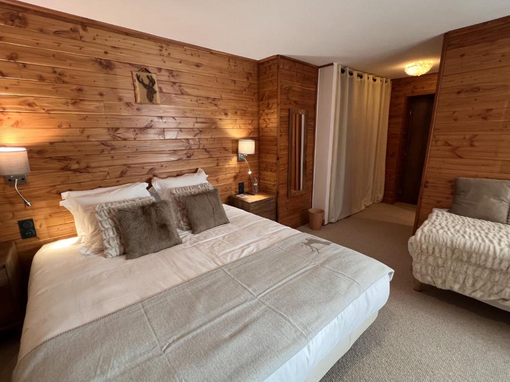 a bedroom with a white bed and a wooden wall at Everest Hotel in Val-d'Isère