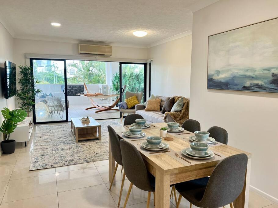 a living room with a wooden table and chairs at Luxurious 2-Bed with Alfresco Balcony & Parking in Brisbane