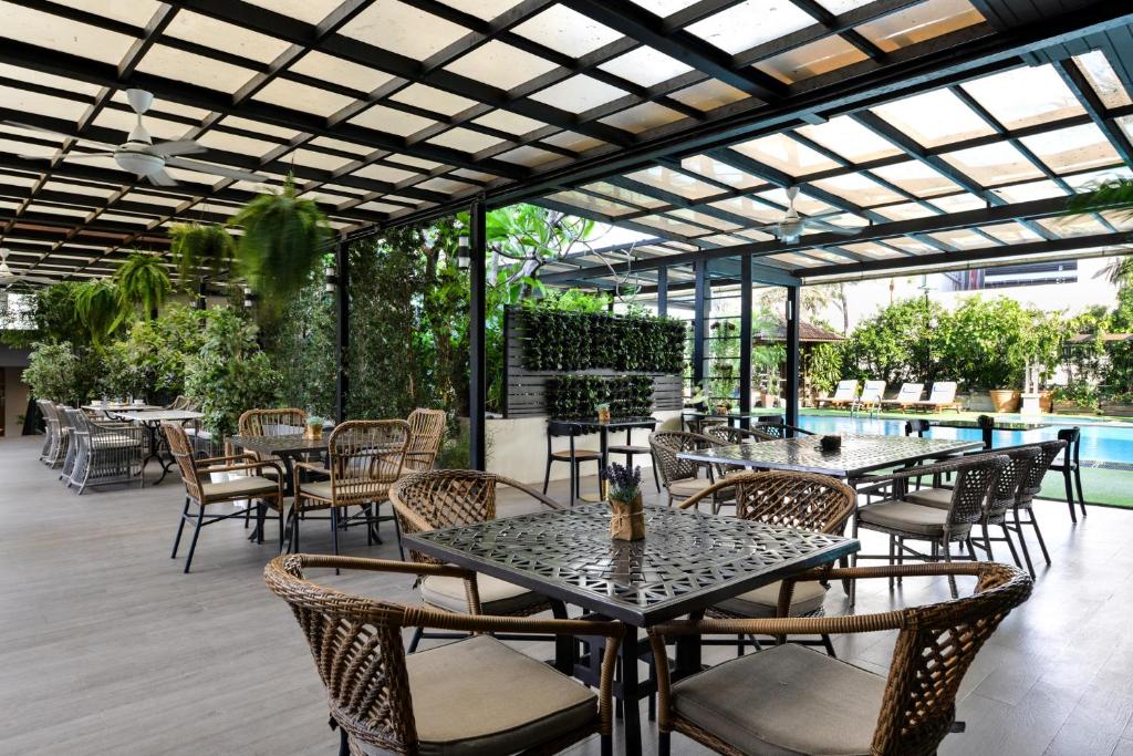 A covered outdoor seating terrace beside a landscaped pool.