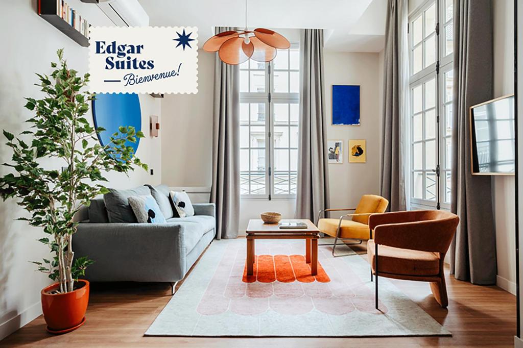 a living room with a couch and a table at Edgar Suites Louvre - Jour in Paris