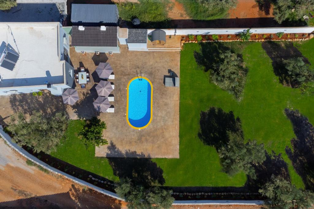 una vista aérea de un patio con piscina en Old olive tree cottage en Áyioi Apóstoloi