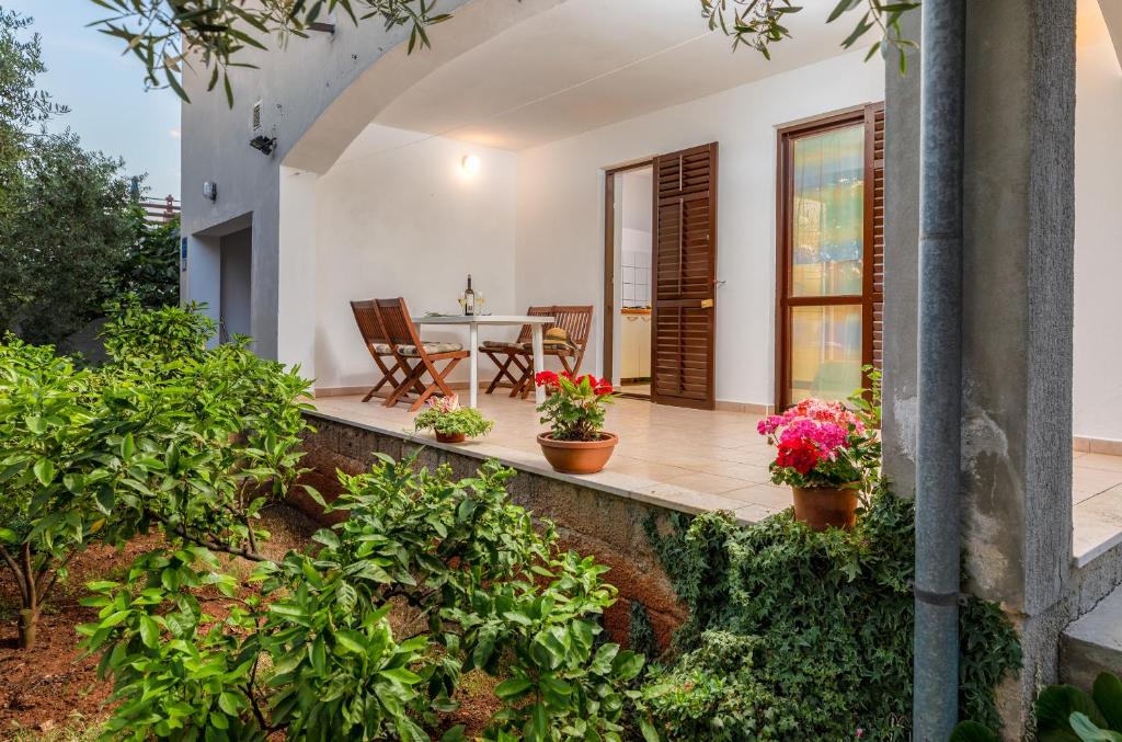 Apartment Luana A2 في فاجانا: فناء مع طاولة وكراسي والنباتات