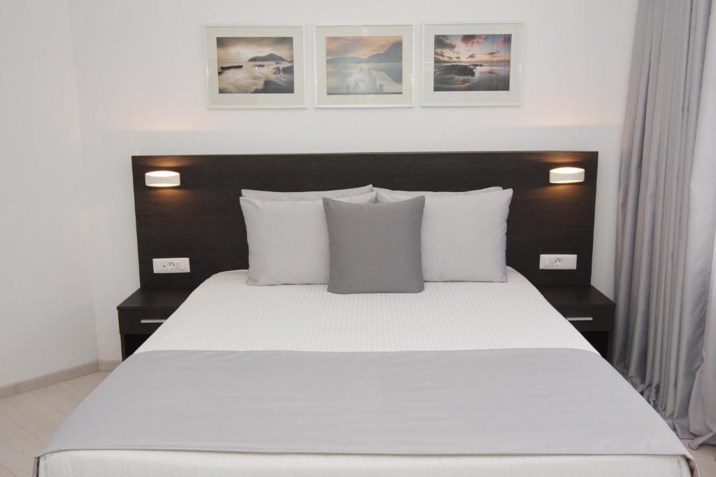 een slaapkamer met een groot bed met witte lakens en kussens bij International Atene hotel in Athene