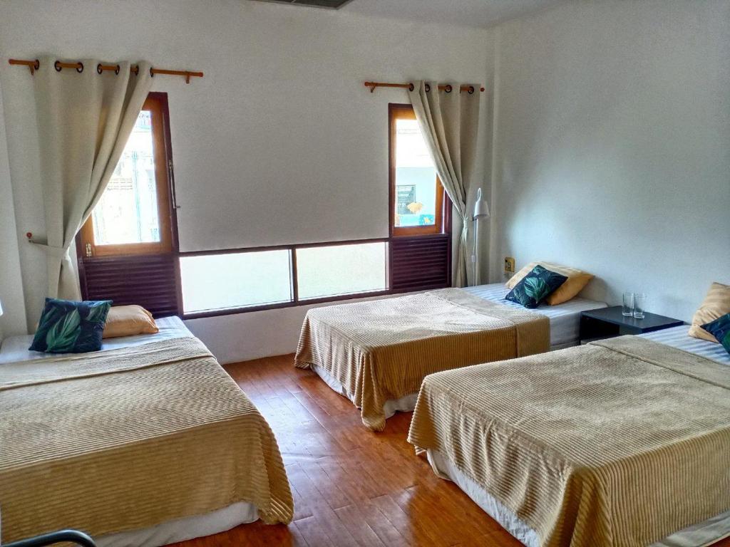 a room with three beds and two windows at Centerpoint Koh Phangan New in Thong Sala