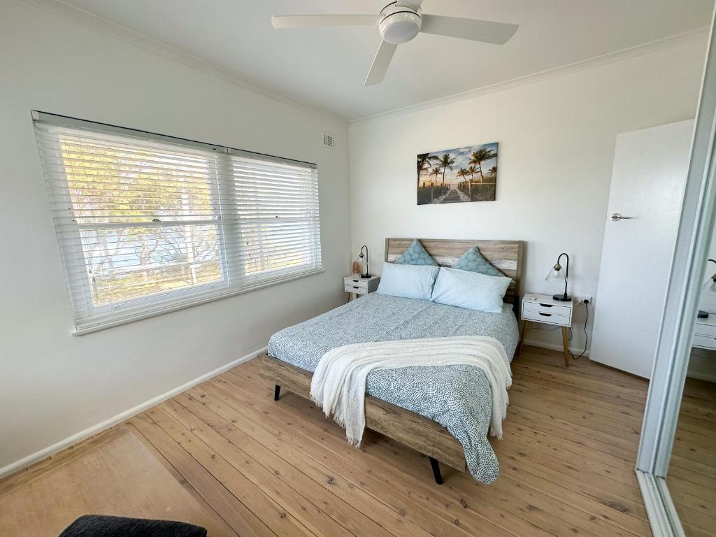 a bedroom with a bed and a window at Esplanade Bliss in Cronulla