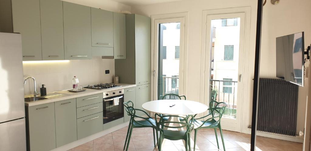 una cocina con mesa y sillas blancas en Venice & Treviso - ANTHEA design apartments, en Casièr