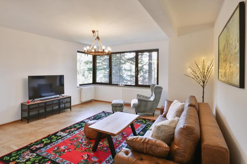 a living room with a couch and a tv at Bellevue Bjelasnica in Bjelašnica