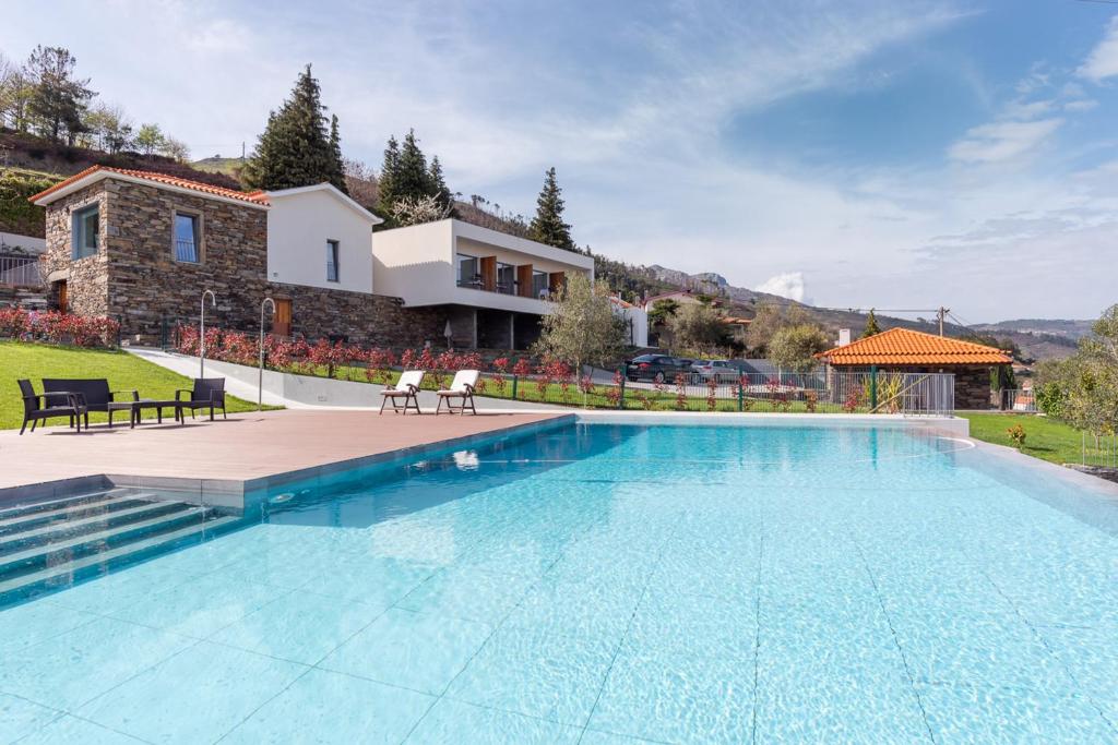 a large swimming pool in front of a house at Feel Discovery Douro LAS House in Peso da Régua
