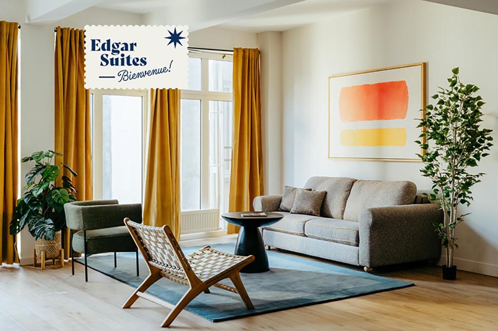 un salon avec un canapé et une chaise dans l'établissement Edgar Suites Montmartre - Abbesses, à Paris