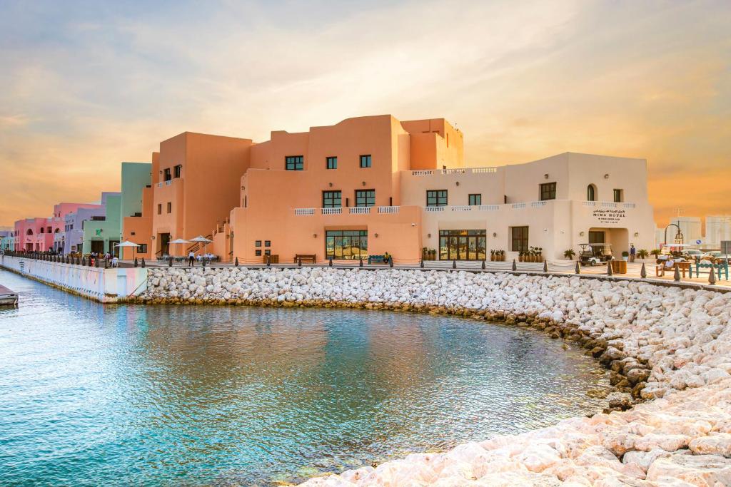 Mina Hotel and Residences في الدوحة: مجموعة مباني بجانب تجمع المياه