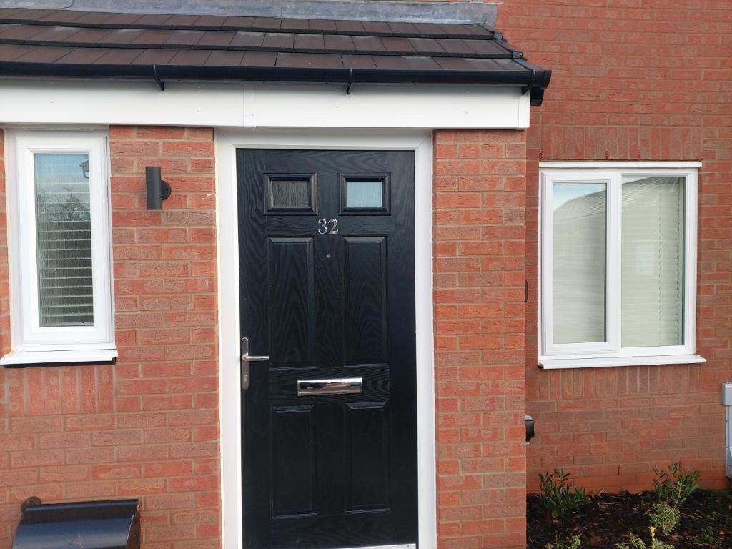 a black door on a red brick house at Remarkable and modern house in Rugby England in Rugby