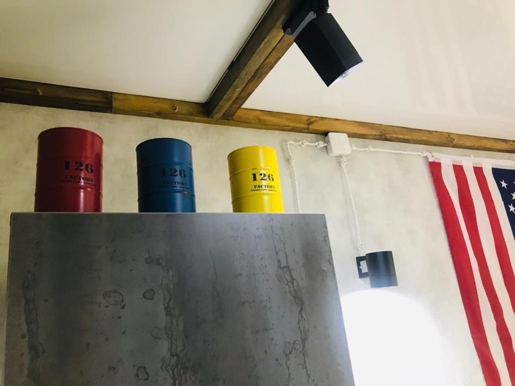 three different colored canisters next to an american flag at Квартира в стиле лофт in Karagandy