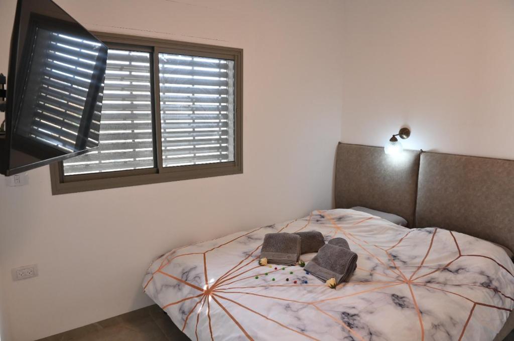 a bedroom with a bed and a window at נוף יובלים in Qiryat Shemona