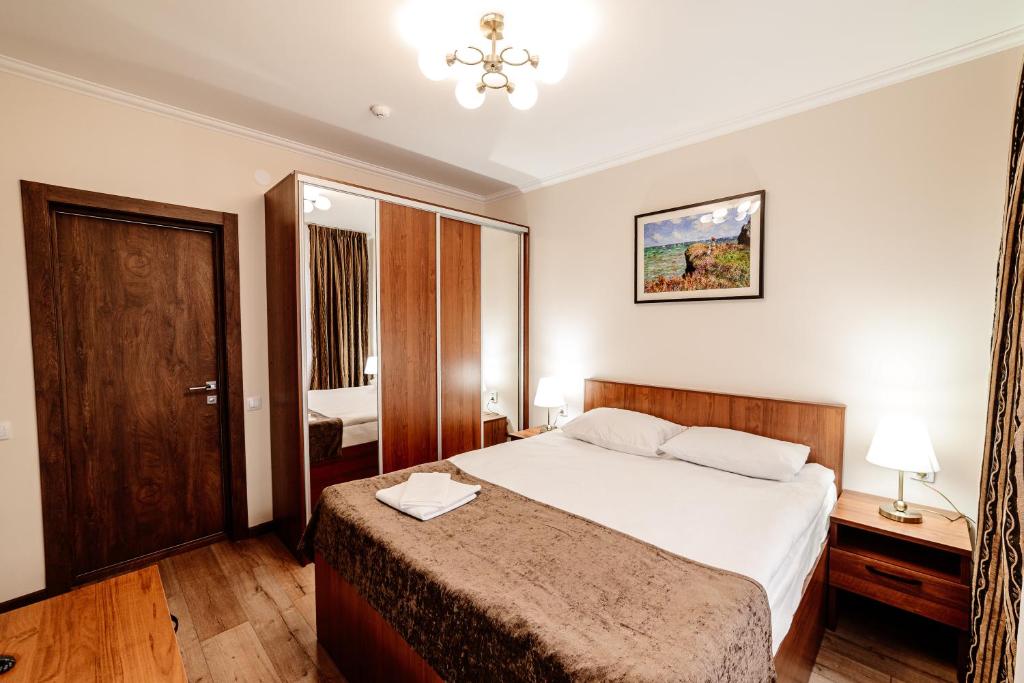 a hotel room with a bed and a mirror at Chagala Hotel Aksai in Aksay