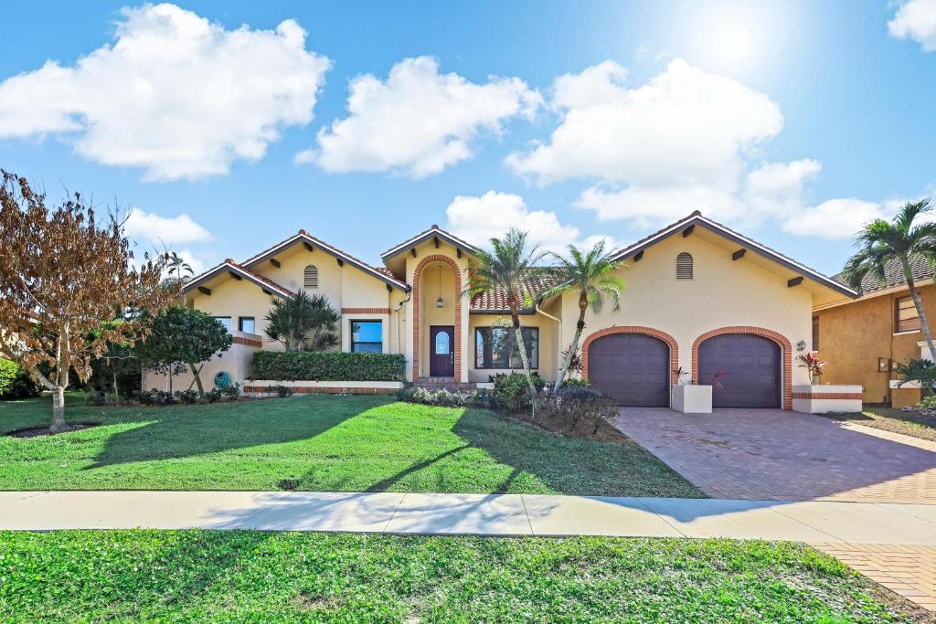 Una casa grande con entrada y césped. en Serene waterfront home with pool, spa, and water view, en Marco Island