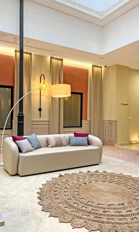a living room with a white couch and a rug at Soho Boutique Cádiz in Cádiz